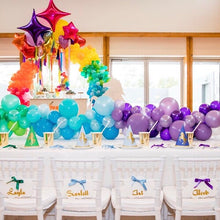 white kids tiffany chairs with rainbow balloms and unicorn decoration at a kids party